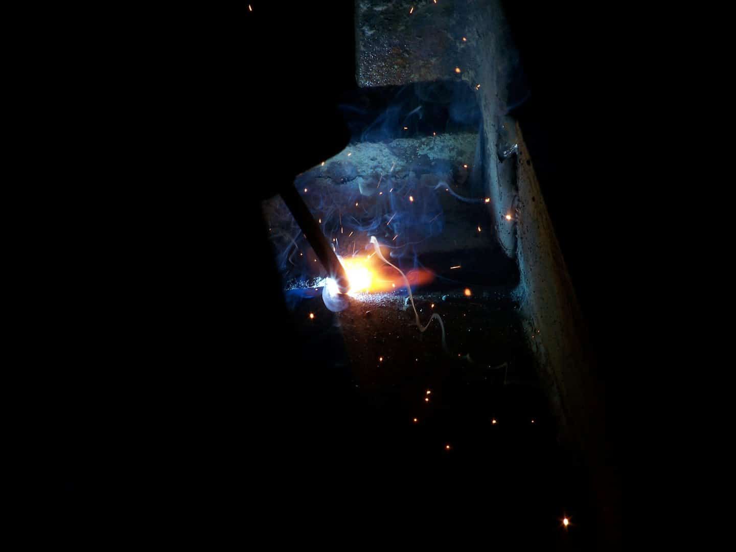 Welder creating sparks with molten metal.
