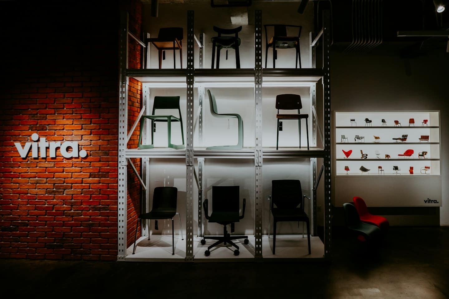 Modern furniture showroom displaying various chairs on metal shelving.